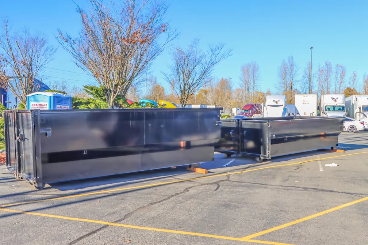 Professional dumpster rental service with roll-off container on residential driveway in White Knoll